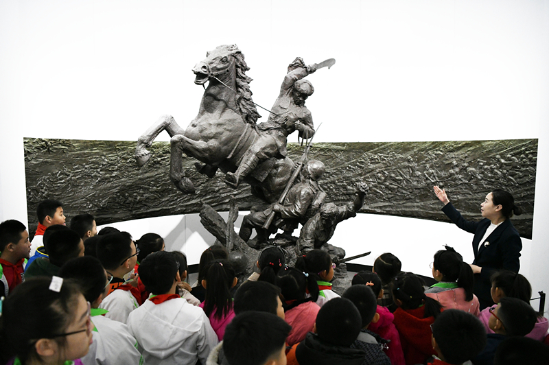 2019年4月4日，在東北烈士紀(jì)念館，學(xué)生們?cè)诼?tīng)講解員講解。